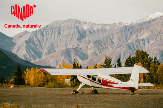 Ein Flugzeug vor einer Berglandschaft in Kanada