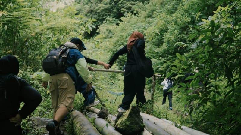 Menschen wandern durch eine von viel Natur geprägte Landschaft